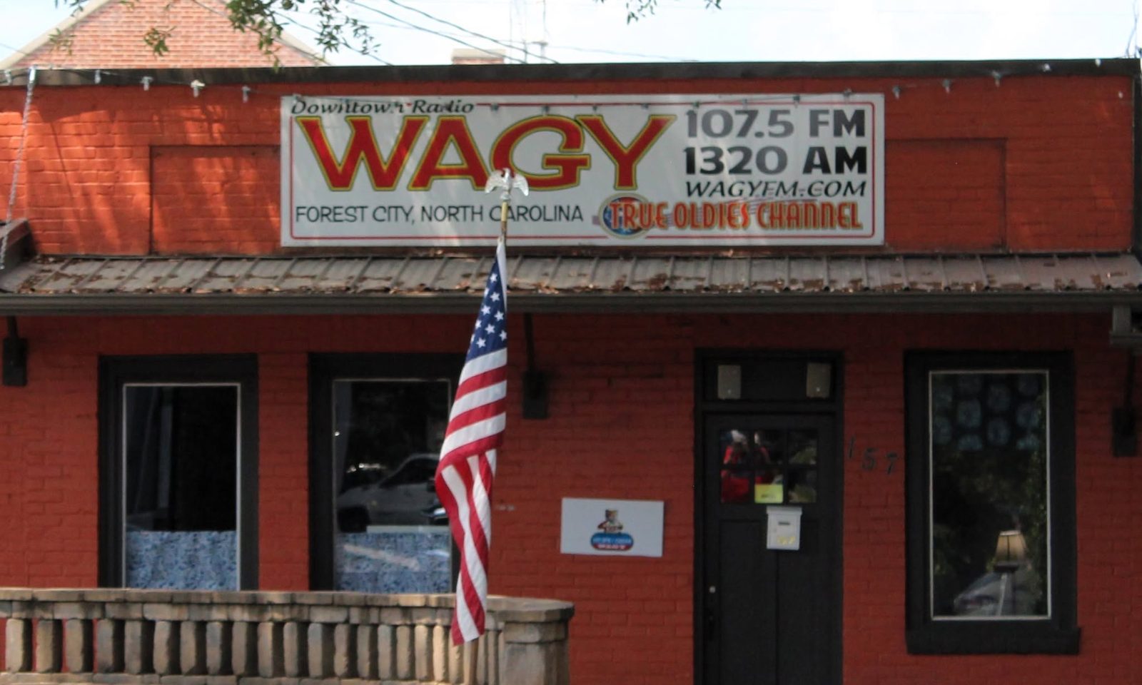 The WAGY studio: a red brick storefront with a hand-painted sign reading Downtown Radio WAGY, 107.5 FM, 1320 AM, Forest City, North Carolina.